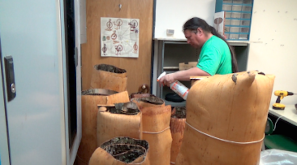 Wayne spraying rolls of birchbark to keep them moist