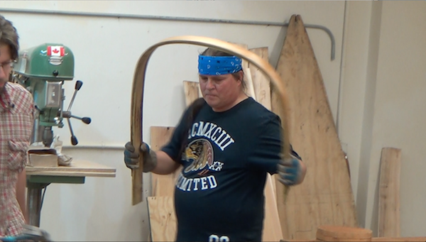 Wayne carrying a pair of bent ribs for installation at center of canoe