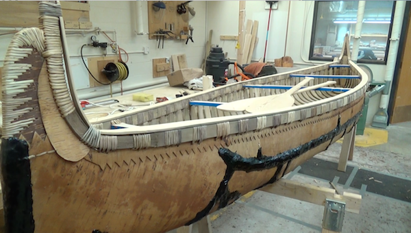 The completed canoe in wood shop, with finished paddles