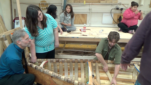 Lifting end of canoe while ribs are being installed