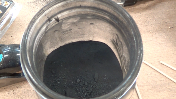 glass can containing ground charcoal