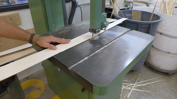 cutting a piece of sheathing on ban saw